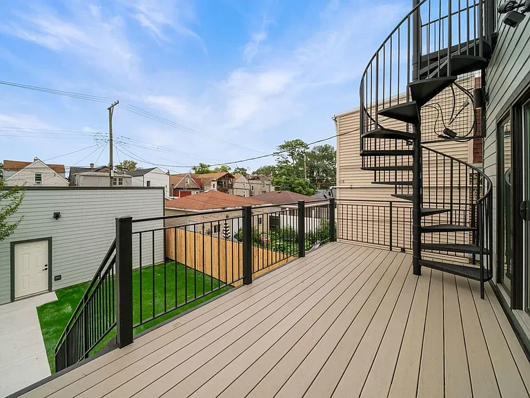 Upper deck with dark metal railing and exterior spiral stairs