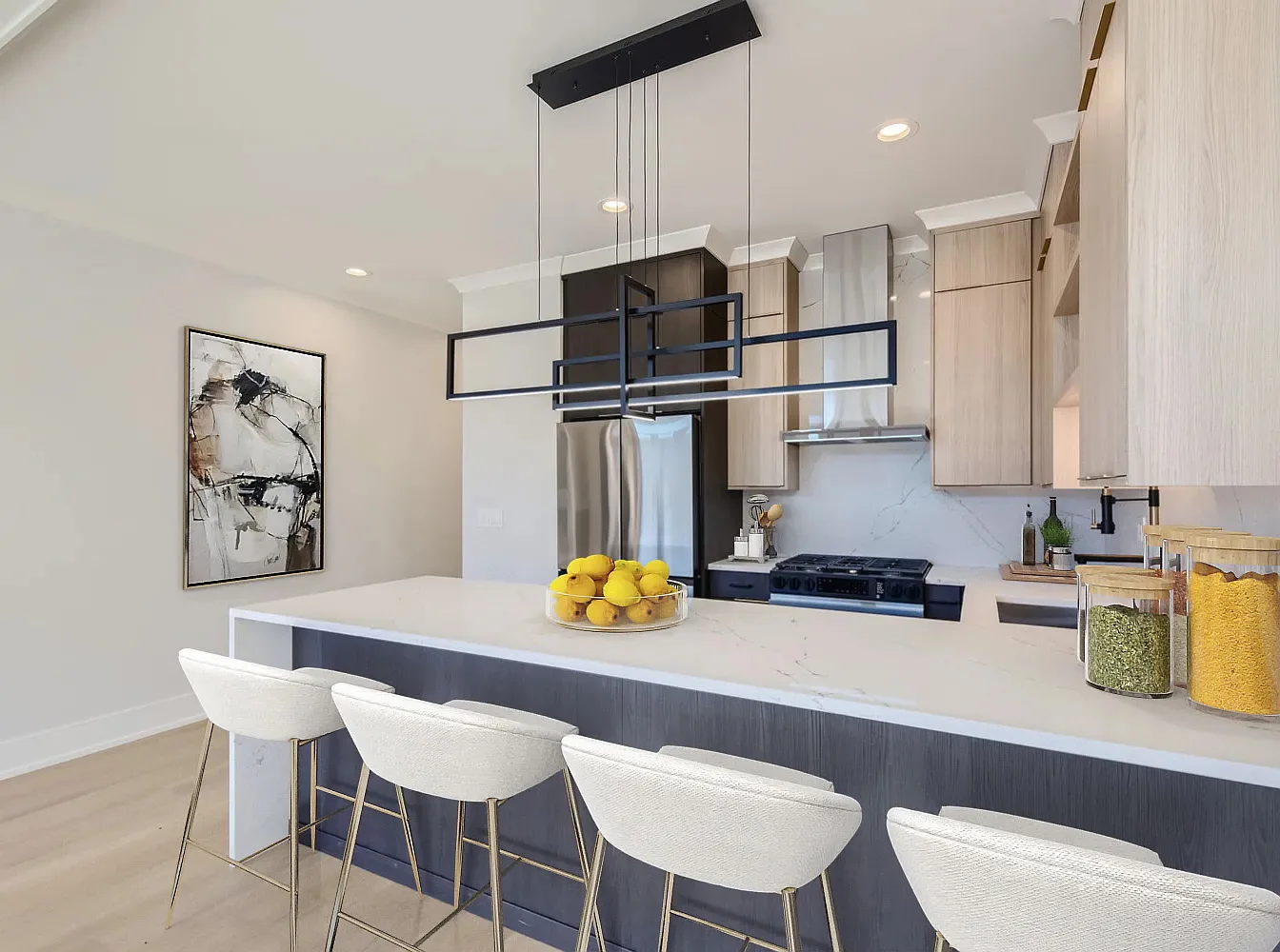 Finished modern kitchen with dark and light cabinetry and architectural island light