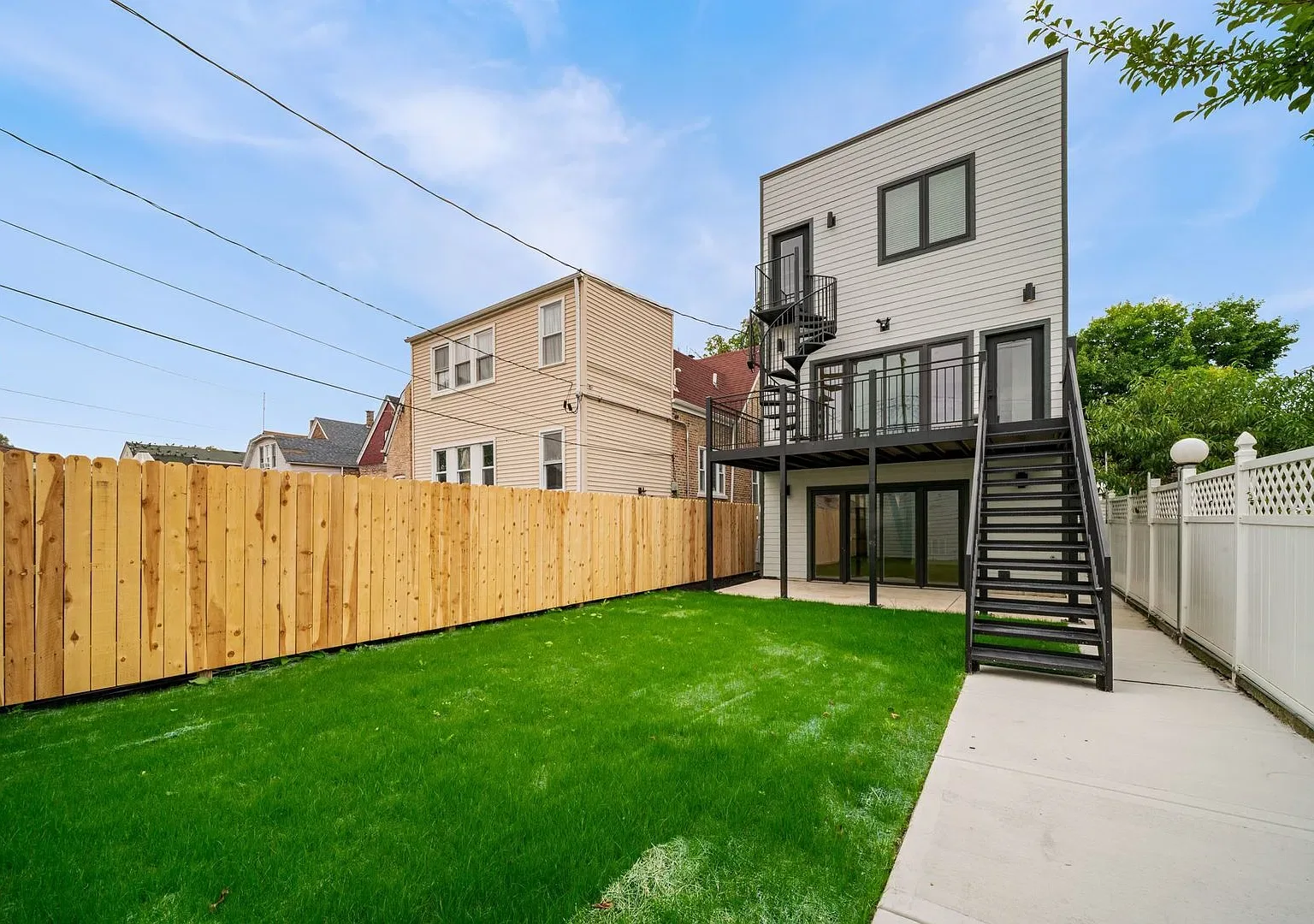Contemporary rear elevation with raised deck, metal stair and garden