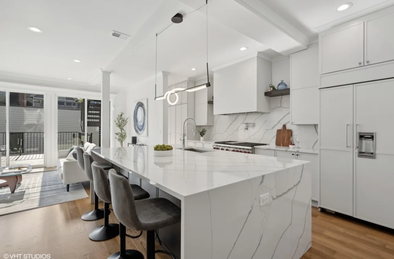 Completed white kitchen with waterfall island and integrated range hood